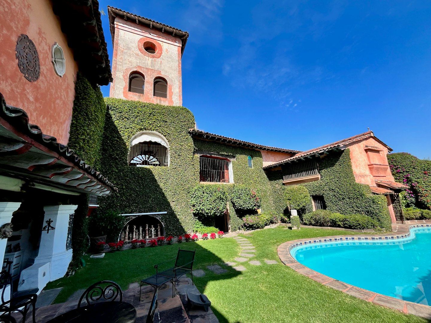 Villa colonial española con piscina y césped cuidado.