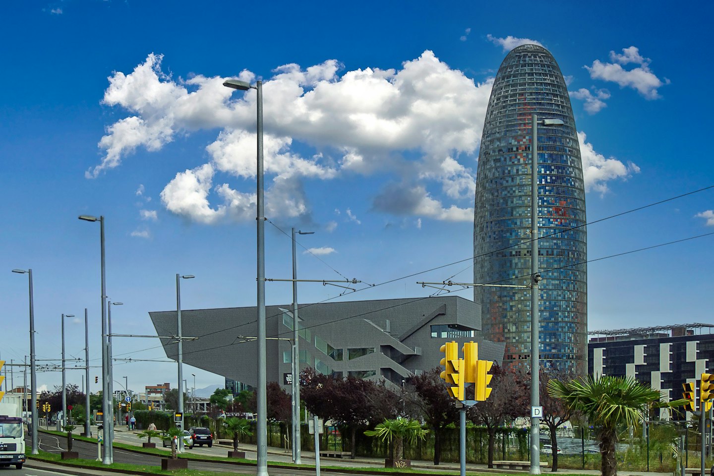 Edificios modernos se elevan sobre una calle concurrida de Barcelona.