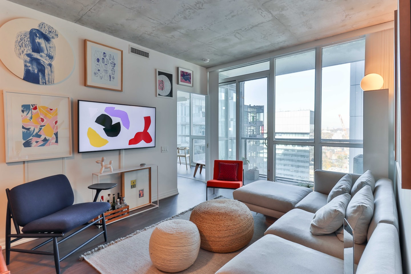 Sala de estar luminosa con sofá seccional y vista a la ciudad.