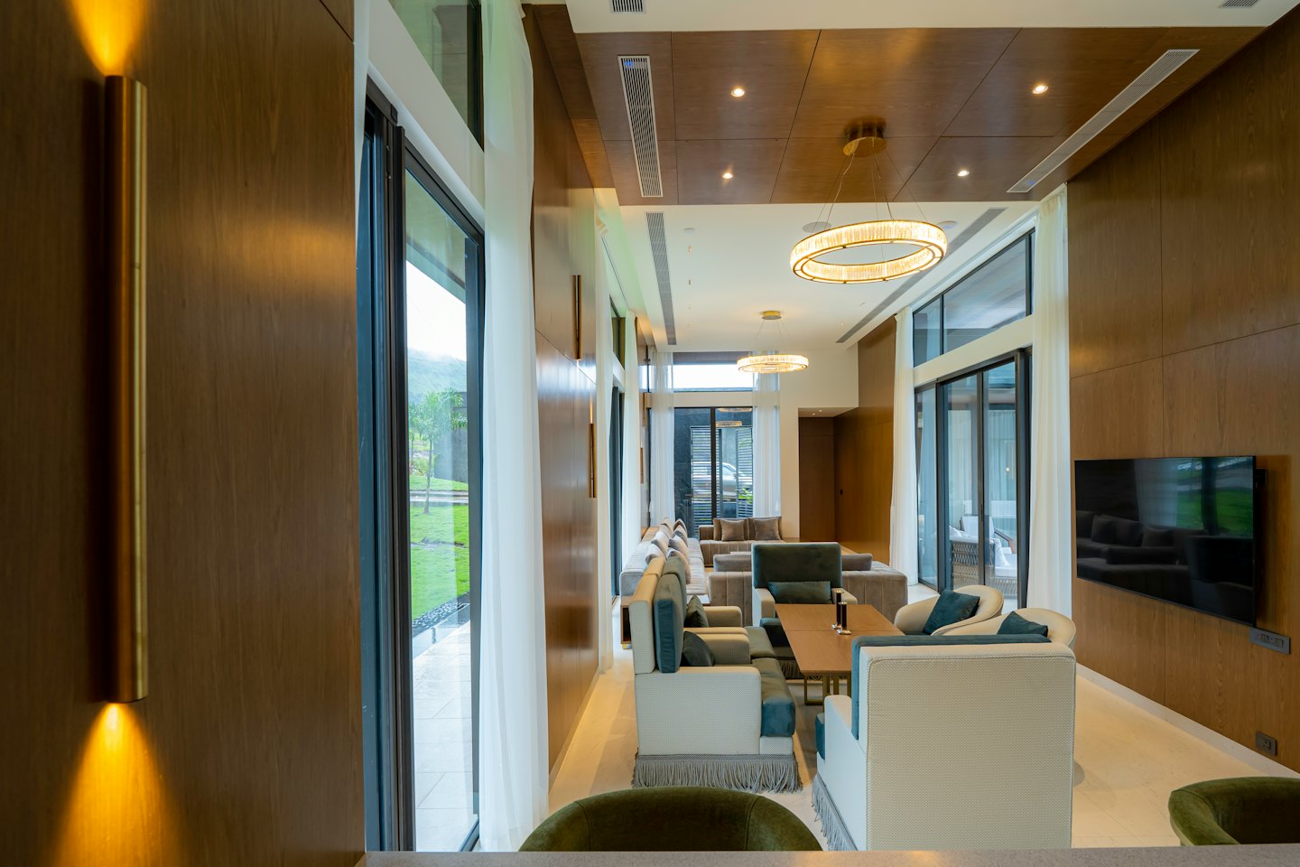 Moderna sala de estar con muebles contemporáneos y grandes ventanales con vistas a las colinas.
